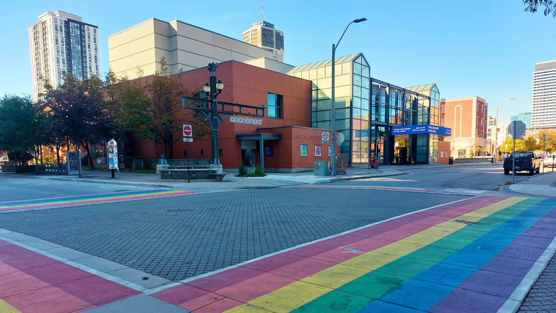 Landscape of Theatre Aquarius building with pride intersection in the foreground