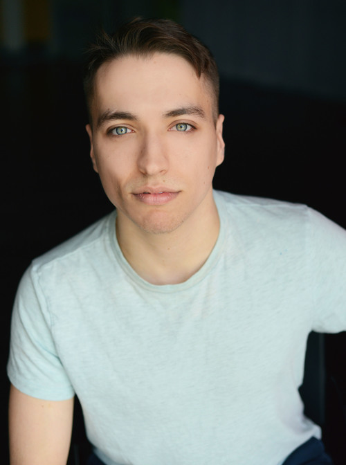 Portrait of person with dark hair wearing light blue shirt