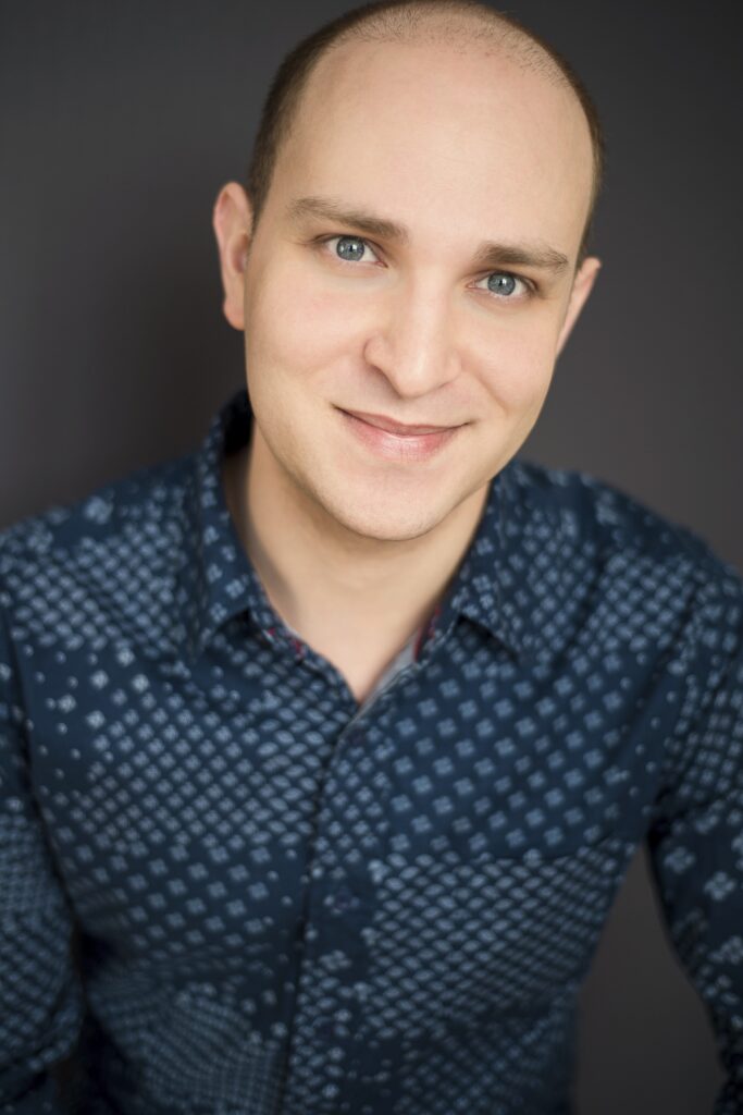 Portrait of a man with wide forehead, blur eyes, and white dotted blue shirt